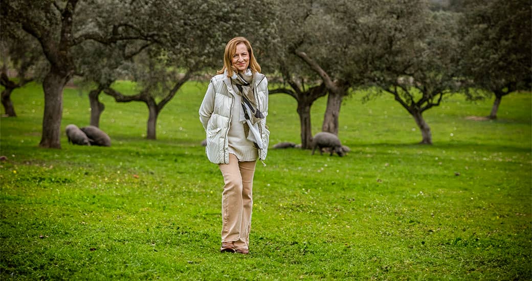 Dos panas paseando su rebaño de cabras por la dehesa